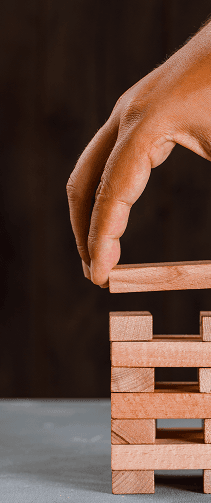 Hands protecting wooden blocks symbolizing company values
